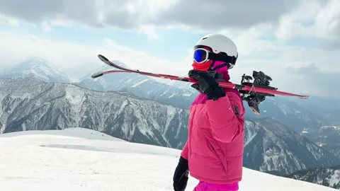 Female beginner skier in bright ski clothing holding carry skis overlooking.. Stock Footage 342964818
