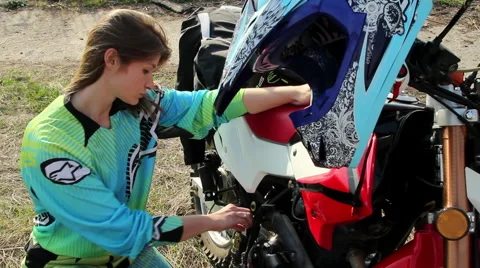 Female Biker Checking the Engine Oil Level in Her Motorcycle Stock Footage 55323748