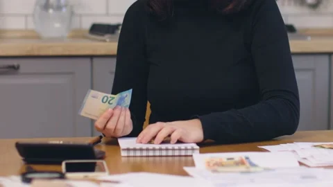 Female in black sit kitchen count coins money hold paper banknotes calculating Stock Footage 211346841
