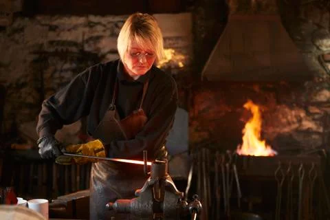 Female blacksmith working in workshop Stock Photos
