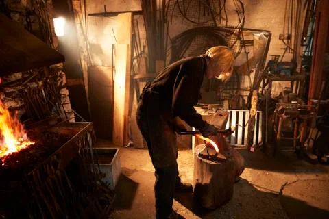 Female blacksmith working in workshop Stock Photos