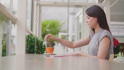 Female blogger using laptop at table in coffee shop Stock Footage 79660026