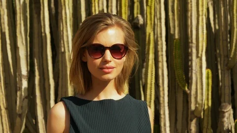Female Blonde Model Posing Sideways by the Group of Cactus Video stock 114172402