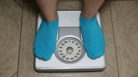 Female with Blue Socks Standing on Weigh, Stock Video