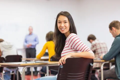 Female with blurred teachers students in classroom Stock Photos