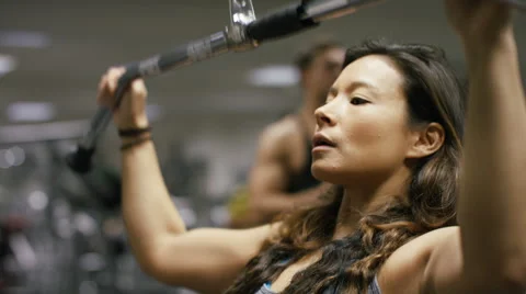 Female body builder using a weights machine in the gym Stock Footage 59714942
