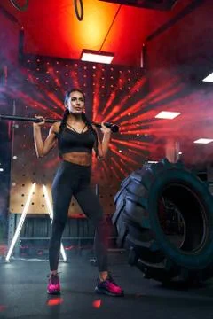 Female bodybuilder posing with sledgehammer. Stock Photos
