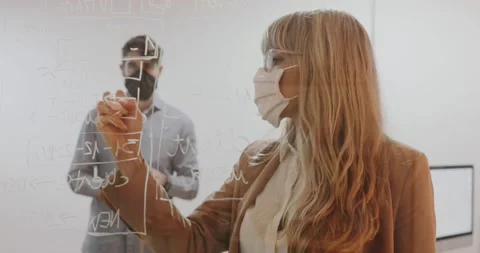 Female boss using a mask presenting a project  Stock Footage 143802158