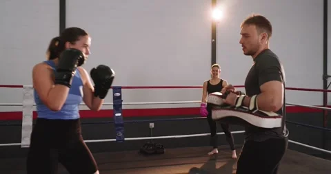 Female boxer in boxing ring throwing jab and cross after coach shifting focus Stock Footage 345123314