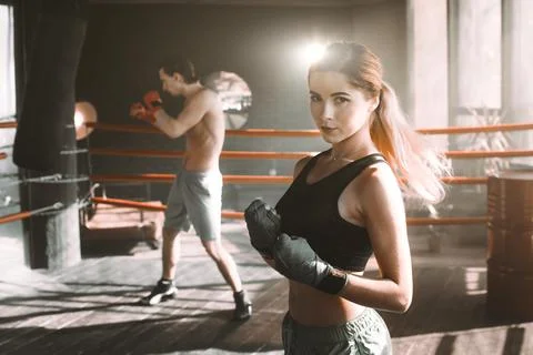 Female boxer doing shadow boxing inside a boxing ring. Boxer practicing her Stock Photos