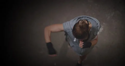 Female boxer fighter practising shadow boxing in abandoned building dark hall. Vidéo 197723393