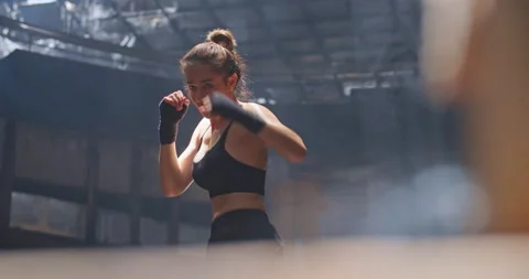Female boxer fighter practising shadow boxing in abandoned building dark hall. Vidéo 197723691