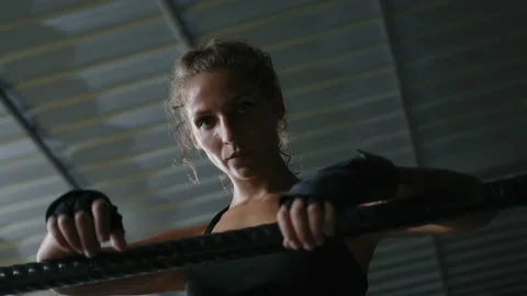 Female boxer leaning on ring ropes in gym looking at camera Stock Footage 239439837