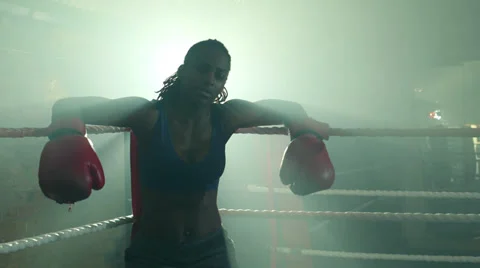 Female Boxer leaps up from the the corner of the Boxing Ring and begins preparin Stock Footage