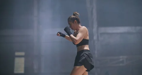 Female boxer practising shadow boxing in abandoned building hall. Slow Motion. Video stock 242445708