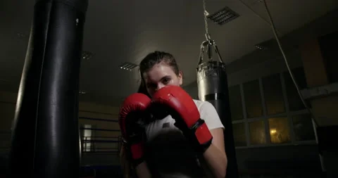 Female boxer punching camera during training. Low angle of sweaty young woman Stock Footage 146995541