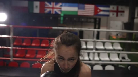 Female boxer punching camera, shadow boxing during workout in dark gym Stock Footage 151030266