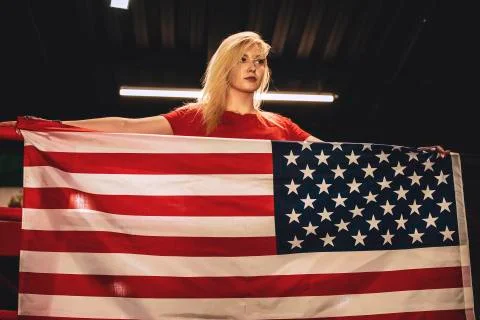 Female boxer with the USA flag is in training near the ring. Patriot and fan  Stock Photos