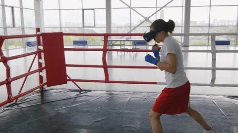 Female Boxer in VR Headset Practicing Punches on Ring Stock Footage 119089899