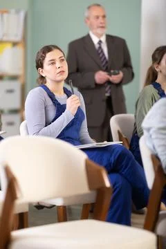 Female builder at a lecture takes notes Stock Photos