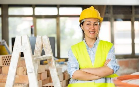 Female builder posing on indoor construction site Stock Photos