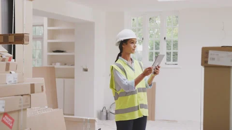 Female Builder Wearing Hard Hat With Digital Tablet Checking Delivery Of New Stock Footage 143286830
