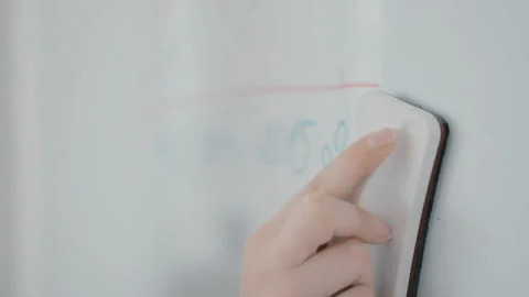 Female business trainer erasing notes on a whiteboard Vídeo Stock 85556356
