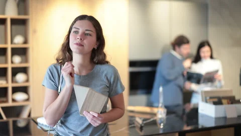 Female buyer with samples of material chooses kitchen set in a furniture store Stock Footage 314765363