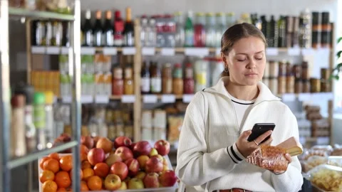 Female buyer scans QR code on cheese label in a grocery store Stockbeeldmateriaal 347262913