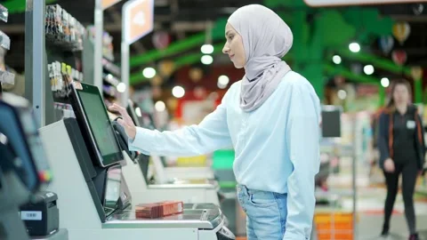 Female buyer using a self-service cashier checkout in a supermarket.  Stock Footage 228778486