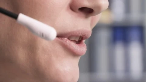 Female call center operator talking to a client using a microphone on headphones Stock Footage 240749525