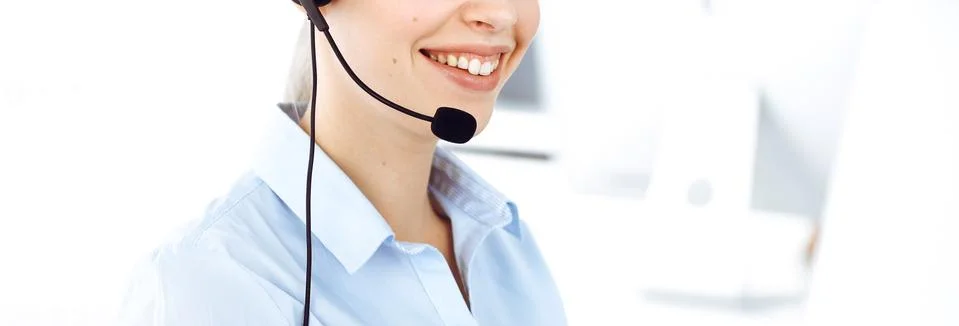 Female call operator is using computer and headset for consulting clients online Stock Photos