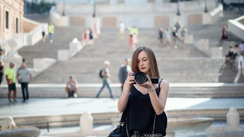 Female camera operator filming beautiful buildings, landmark and walking people Stock-Footage 129370608