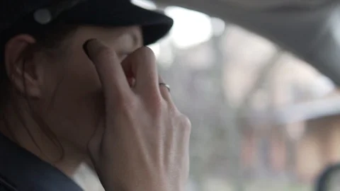 A female car driver puts a protective mask on her face during a coronavirus Stock Footage 128379903