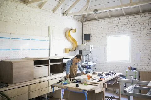 Female carpenter at workbench in workshop Stock Photos