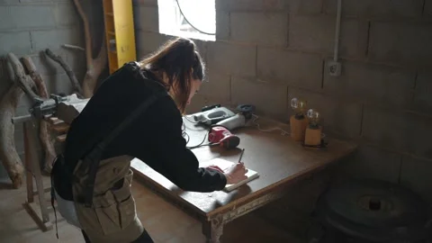 Female carpenter writing in notebook in workshop Stock Footage 167421538