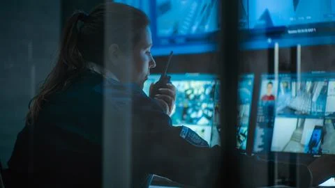 Female CCTV operator works on computer in monitoring center with security Foto stock
