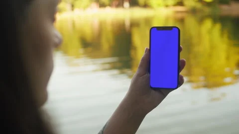 Female with cellphone chroma key screen in the lovely park close-up. Girl with Видео 252698412