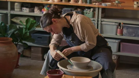 Female Ceramic Artist Using Torch to Dry Clay Bowl in Workshop Stock Footage 319231601