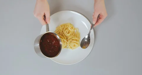 Female chef adding Bolognese sauce to delicious pasta on plate Stock Footage 129326287