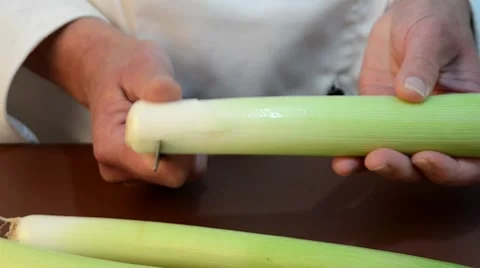 Female chef cleans leek with a kitchen knife Stock Footage 8829581