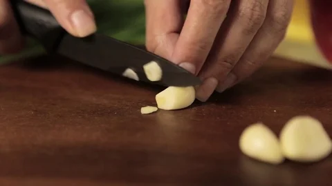 Female chef cuts the garlic Video stock 77364764