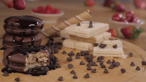 Female chef decorating delicious soft cream-filled cookies with red strawberry Stock-Footage 153199731