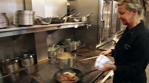 Female Chef Gesturing and Explaining Food Preparation in Restaurant Kitchen Stockbeeldmateriaal 343765047