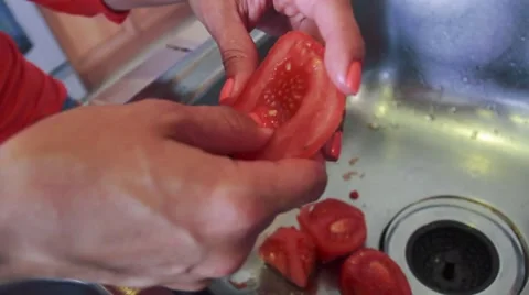 Female chef hands removing seeds from a tomato with her fingers Stock Footage 45281157