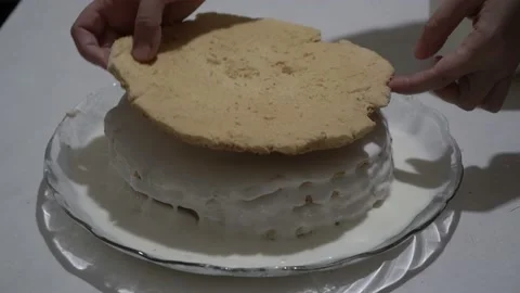 The female chef puts a new layer on the biscuit cake and smears it with cream 스톡 동영상 107276563