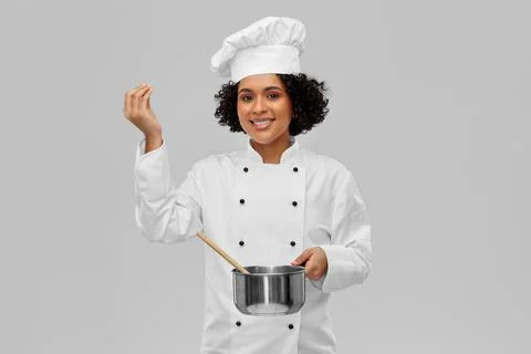Female chef with saucepan and spoon cooking food Stock Photos
