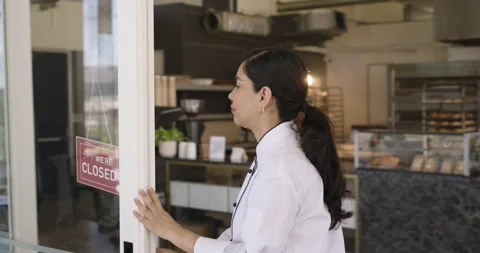 Female chef seeing closed sign, moving to glass door, sliding open, swapping Stock Footage 342023554