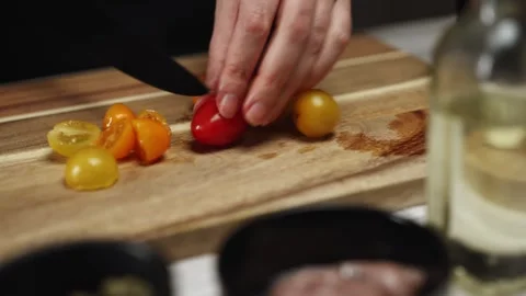 Female Chef Slicing Cherry Tomatoes with Sharp Knife. Stock Footage 309930462