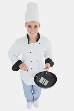 Female chef with spatula and frying pan Stock Photos